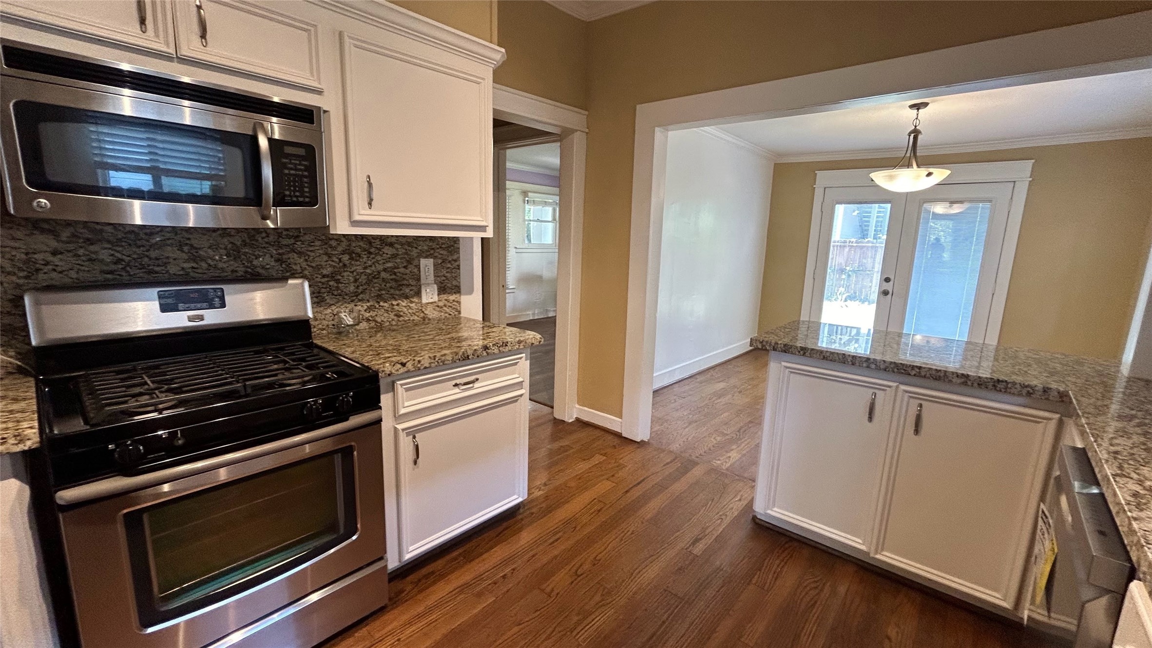 209 Walton Street Houston, TX 77009 - Photo 10 of 24 a kitchen with granite countertop wooden cabinets stainless steel appliances and wooden floor