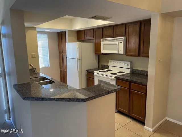 a kitchen with kitchen island granite countertop a sink stainless steel appliances and cabinets