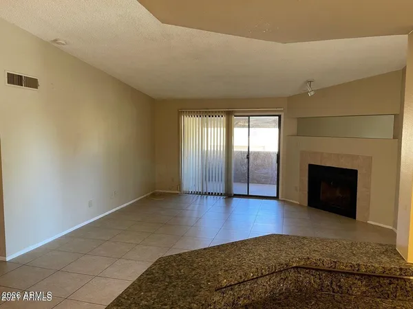 a view of an empty room with a fireplace and a window