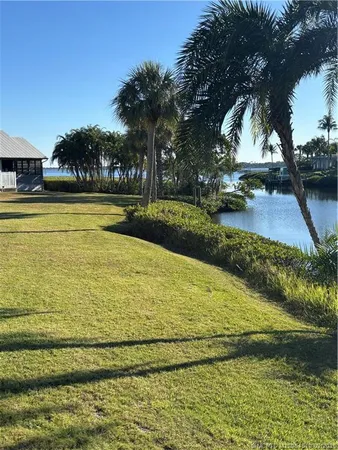 a view of swimming pool with lawn chairs and plants