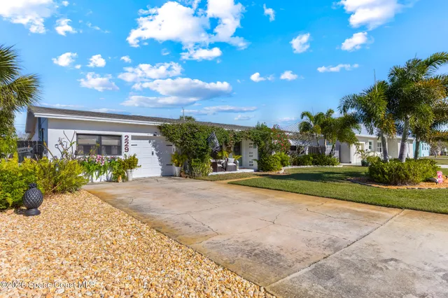 a view of a house with a yard and potted plants
