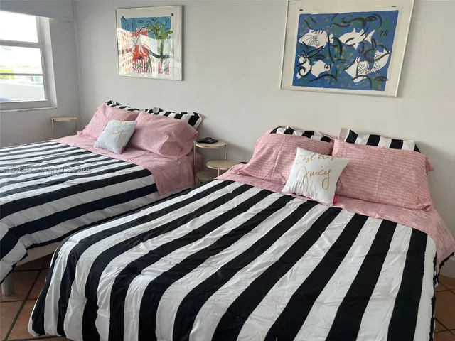 a bedroom with bed and a painting on the wall