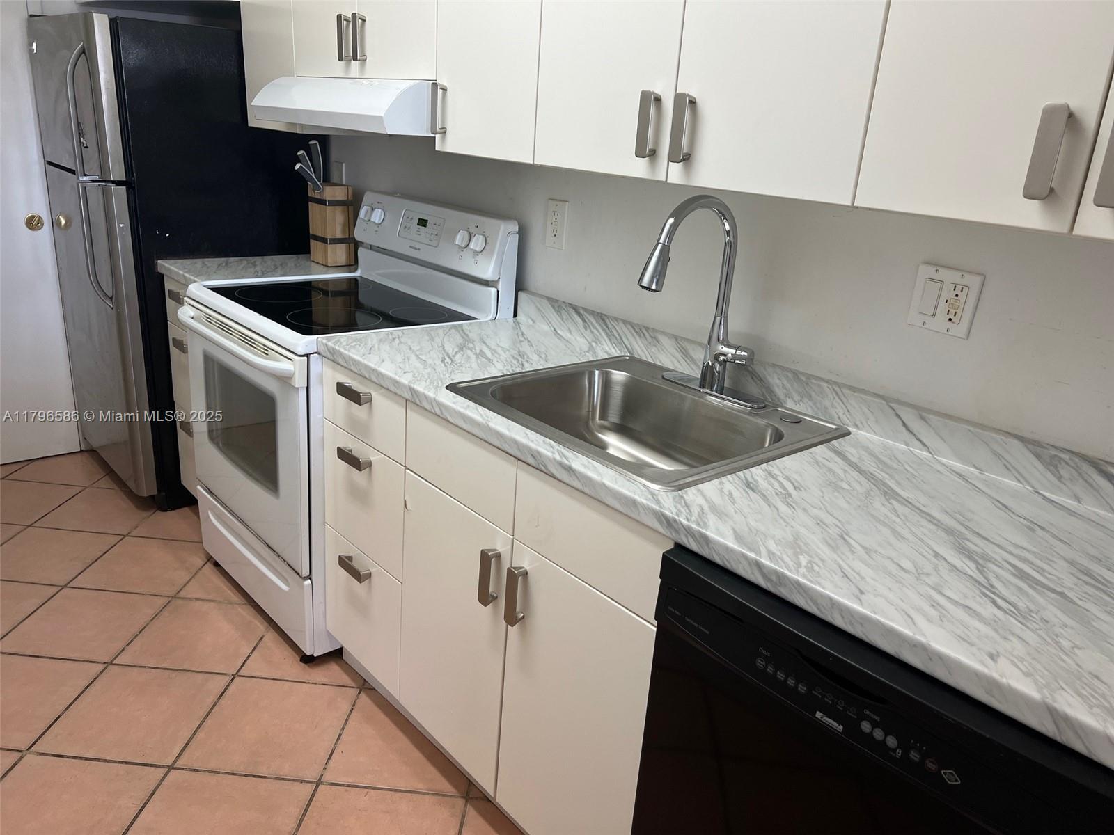 100 Lincoln Road, Unit 1209 Miami Beach, FL 33139 - Photo 16 of 52 a kitchen with granite countertop a sink a stove and cabinets