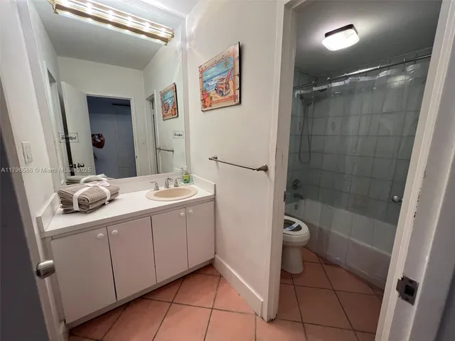 a bathroom with a double vanity sink a toilet a mirror and shower