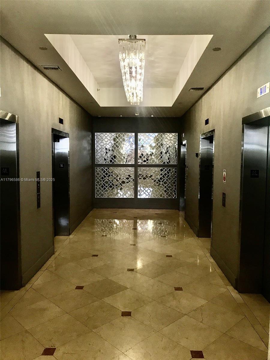100 Lincoln Road, Unit 1209 Miami Beach, FL 33139 - Photo 24 of 52 a view of a hallway with a chandelier