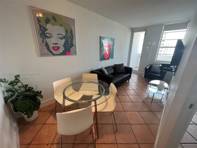 a living room with furniture and a painting on the wall