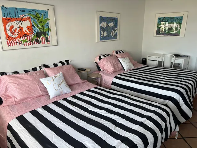 a bedroom with a bed and painting on the wall