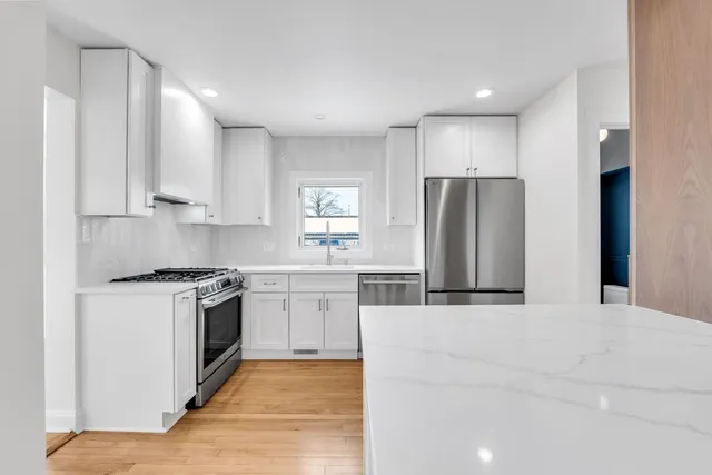 a kitchen with stainless steel appliances granite countertop a stove a refrigerator and a sink