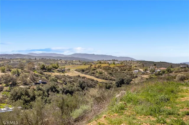 a view of a dry yard with mountains in the background