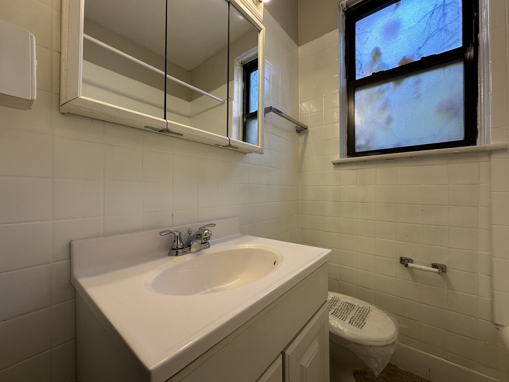 661 West Sheridan Road, Unit 208 Chicago, IL 60613 - Photo 18 of 20 a bathroom with a sink a toilet and mirror