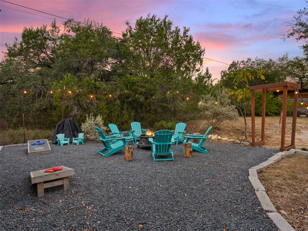 3500 R O Drive Spicewood, TX 78669 - Photo 17 of 40 a view of a backyard with lawn chairs and a fire pit