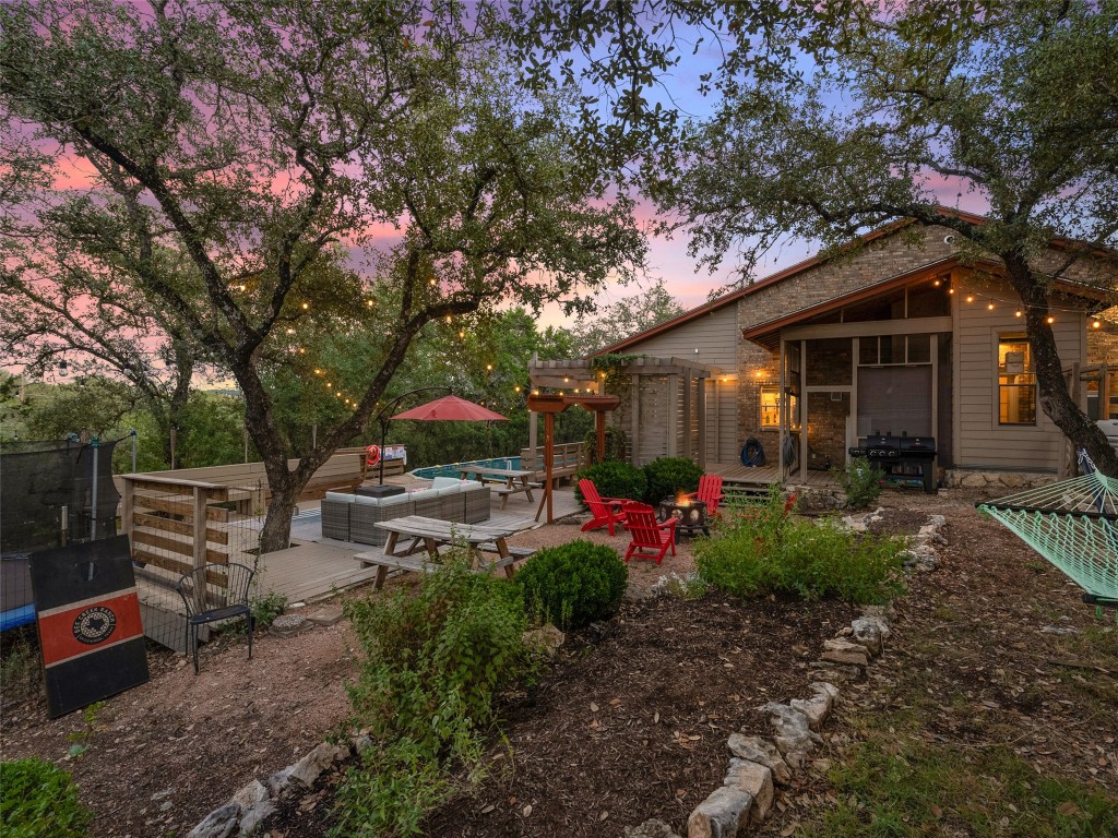 3500 R O Drive Spicewood, TX 78669 - Photo 8 of 40 a view of a patio with table and chairs potted plants and large tree