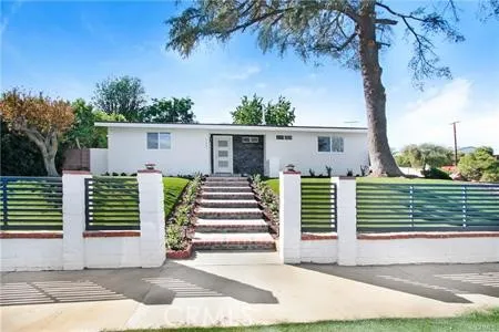 a view of a house with a small yard and plants
