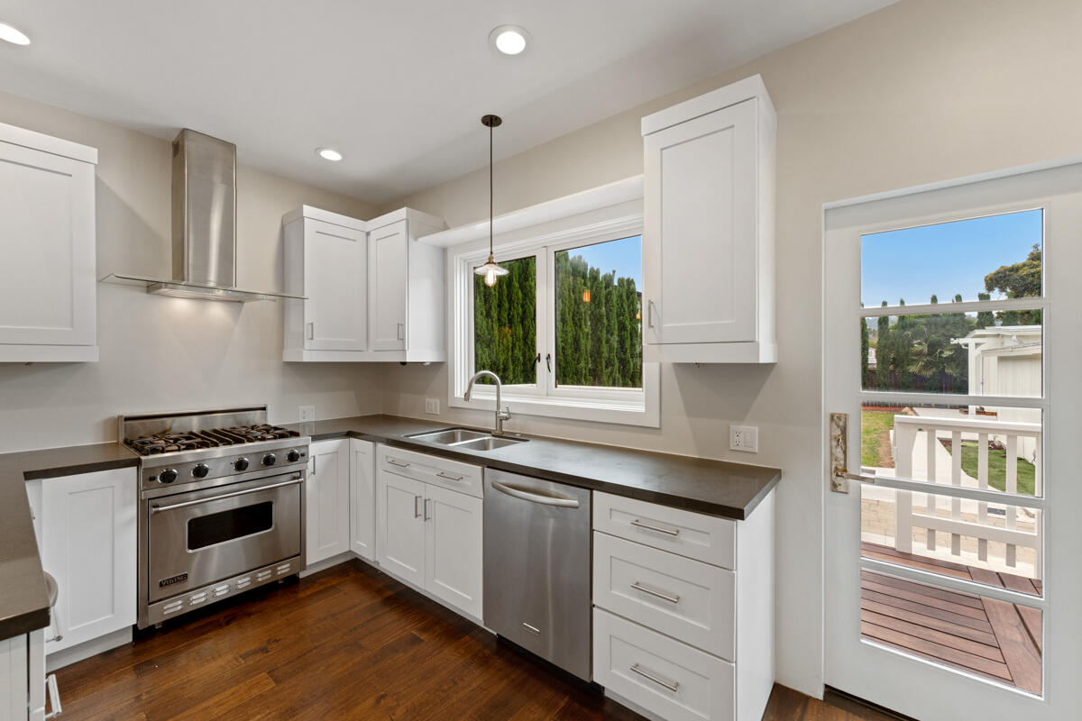 1309 Castillo Street Santa Barbara, CA 93101 - Photo 22 of 41 a kitchen with granite countertop white cabinets and white appliances