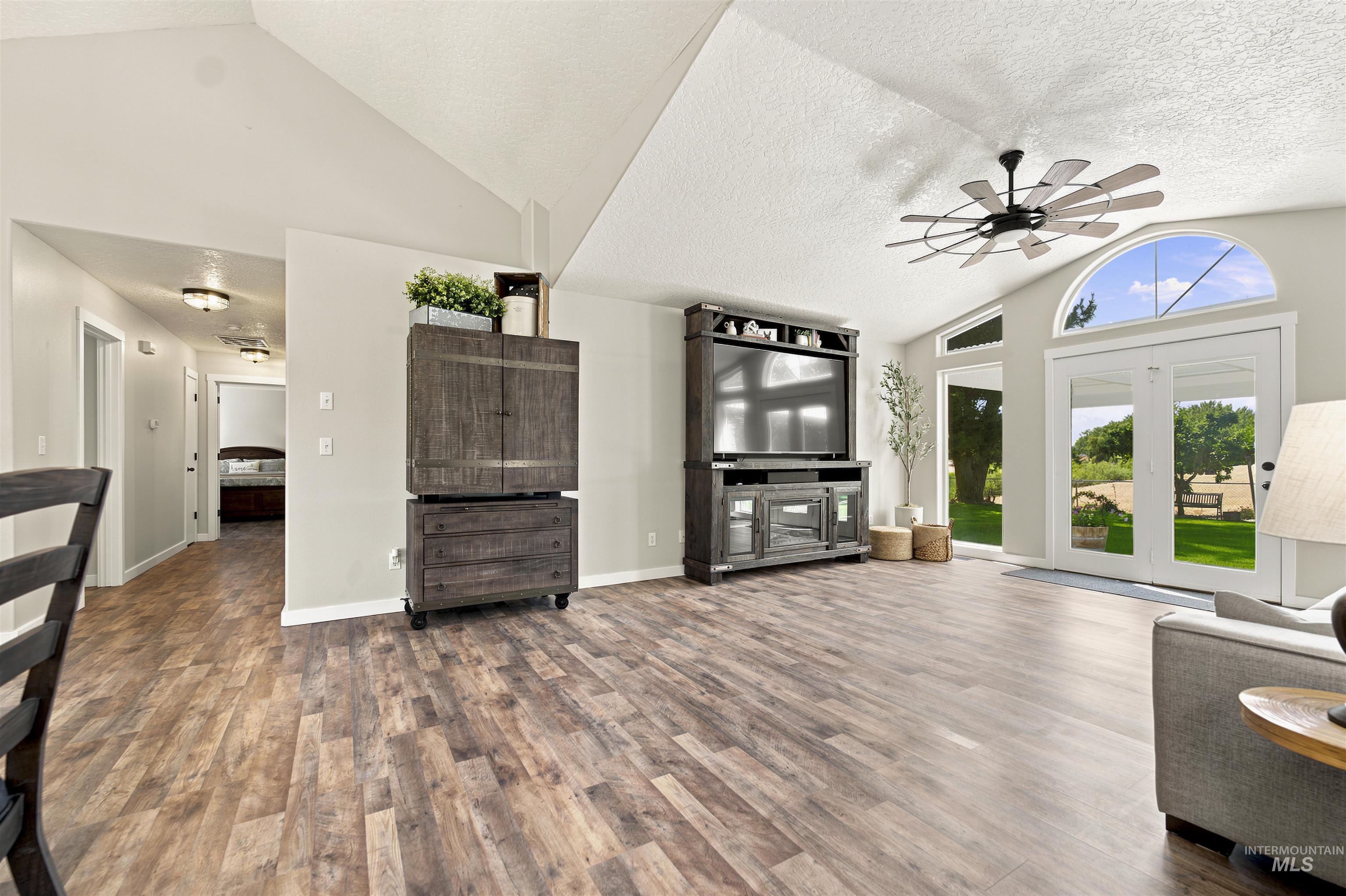 24864 Coventry Drive Caldwell, ID 83607 - Photo 15 of 49 Spacious living area featuring wood-finish flooring, vaulted ceilings, and a modern ceiling fan
