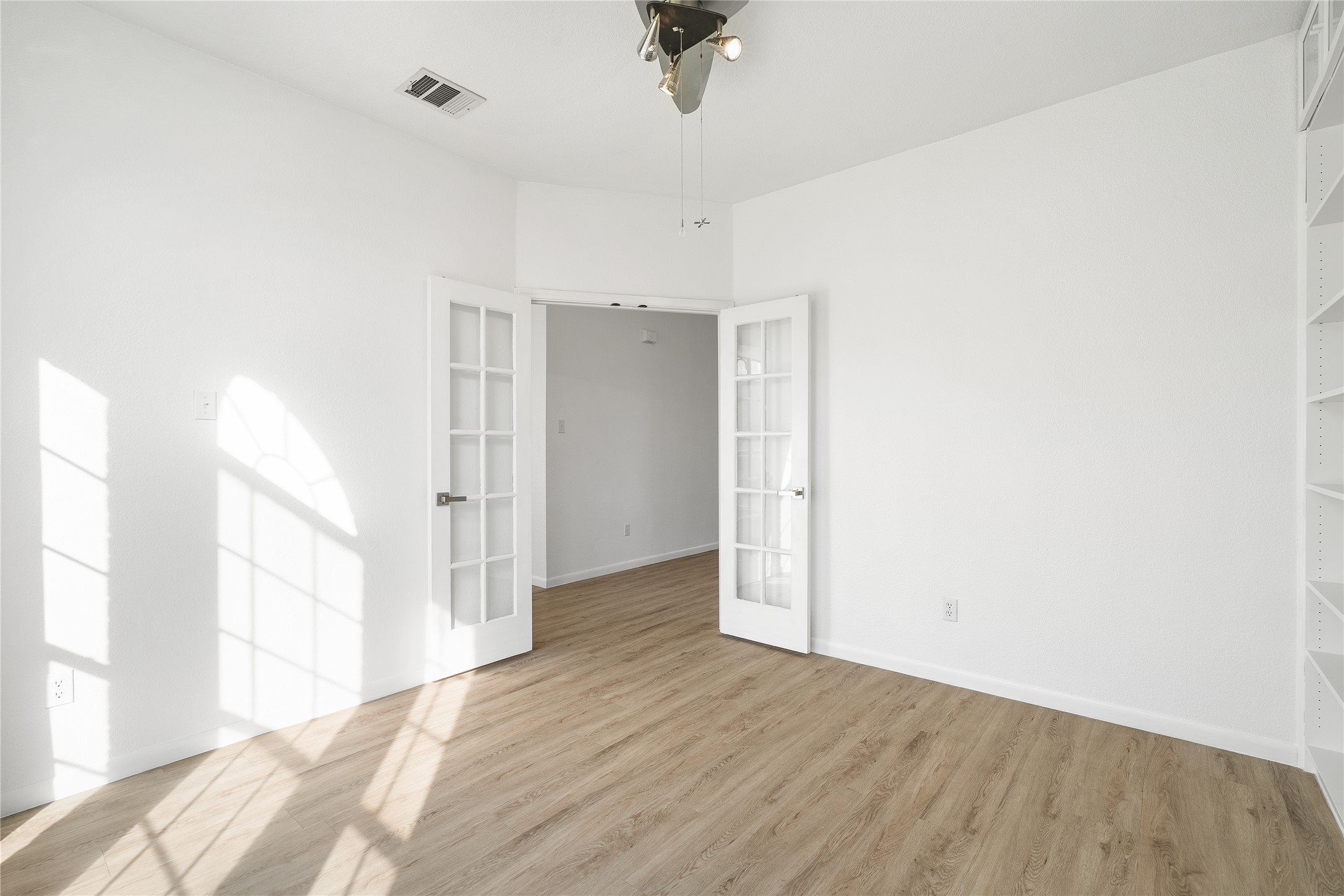 206 River Down Road Georgetown, TX 78628 - Photo 9 of 39 Bright interior room featuring wood-finish flooring, white walls, and a ceiling fan with integrated lighting