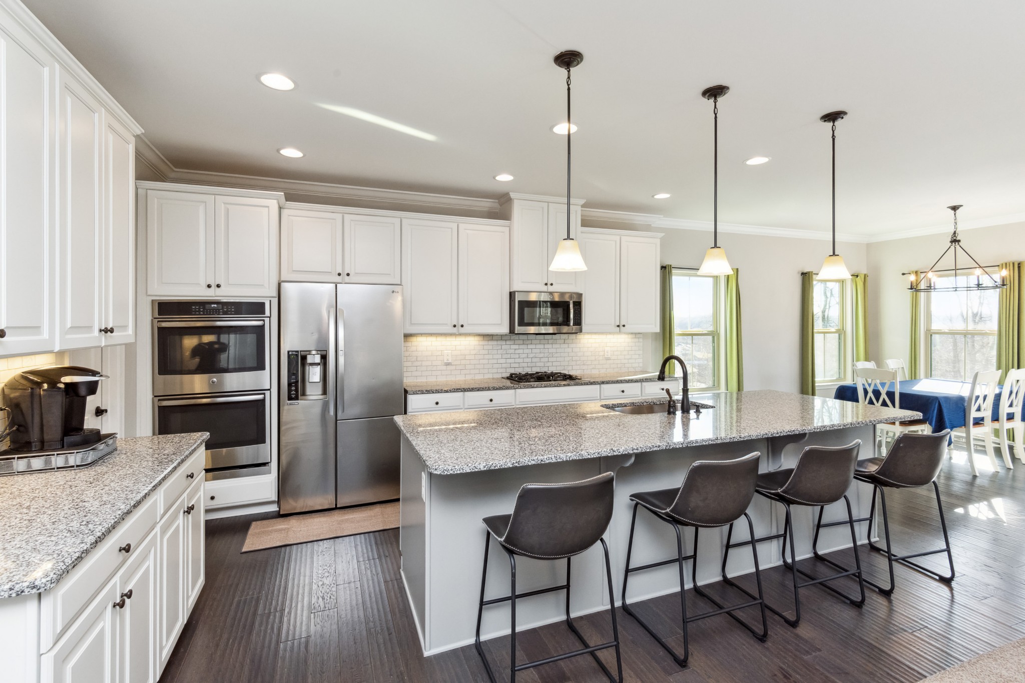 6820 Falls Ridge Lane College Grove, TN 37046 - Photo 8 of 46 a kitchen with stainless steel appliances granite countertop a kitchen island a stove a refrigerator a oven a sink with island chairs and wooden floor