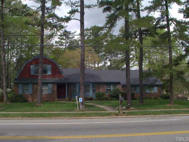 1621 Ridge Road Raleigh, NC 27607 - Photo 1 of 1 a view of a brick house next to a yard with big trees