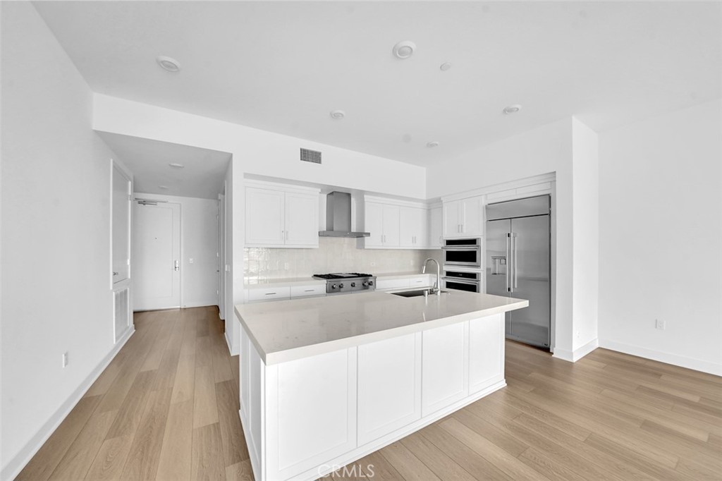 a large white kitchen with stainless steel appliances