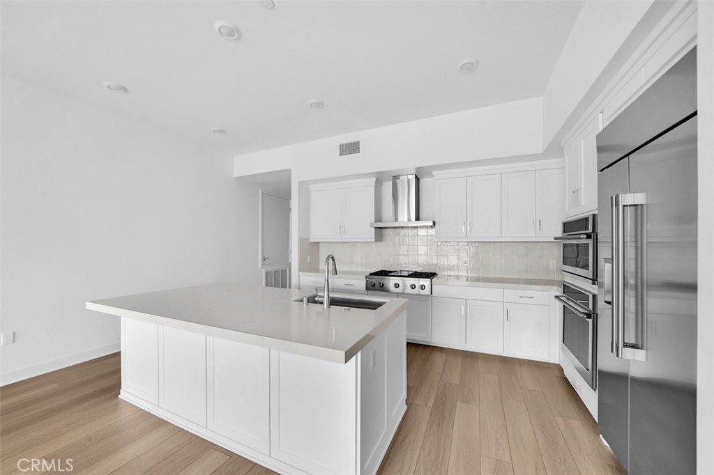 2708 Rivington Irvine, CA 92612 - Photo 2 of 24 a kitchen with white cabinets sink and stainless steel appliances