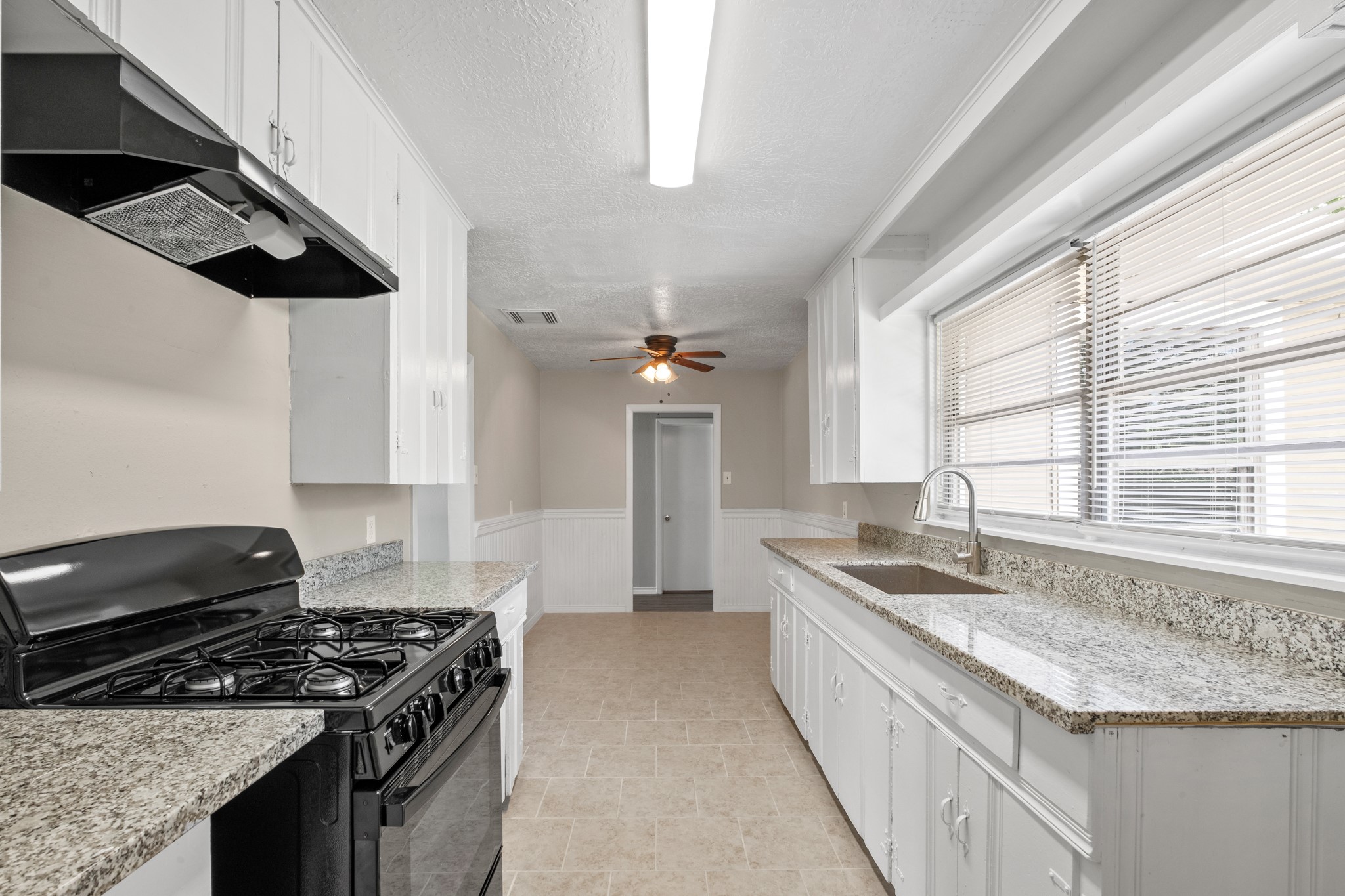 3206 Washington Street Pasadena, TX 77503 - Photo 4 of 12 a kitchen with granite countertop a sink and a stove