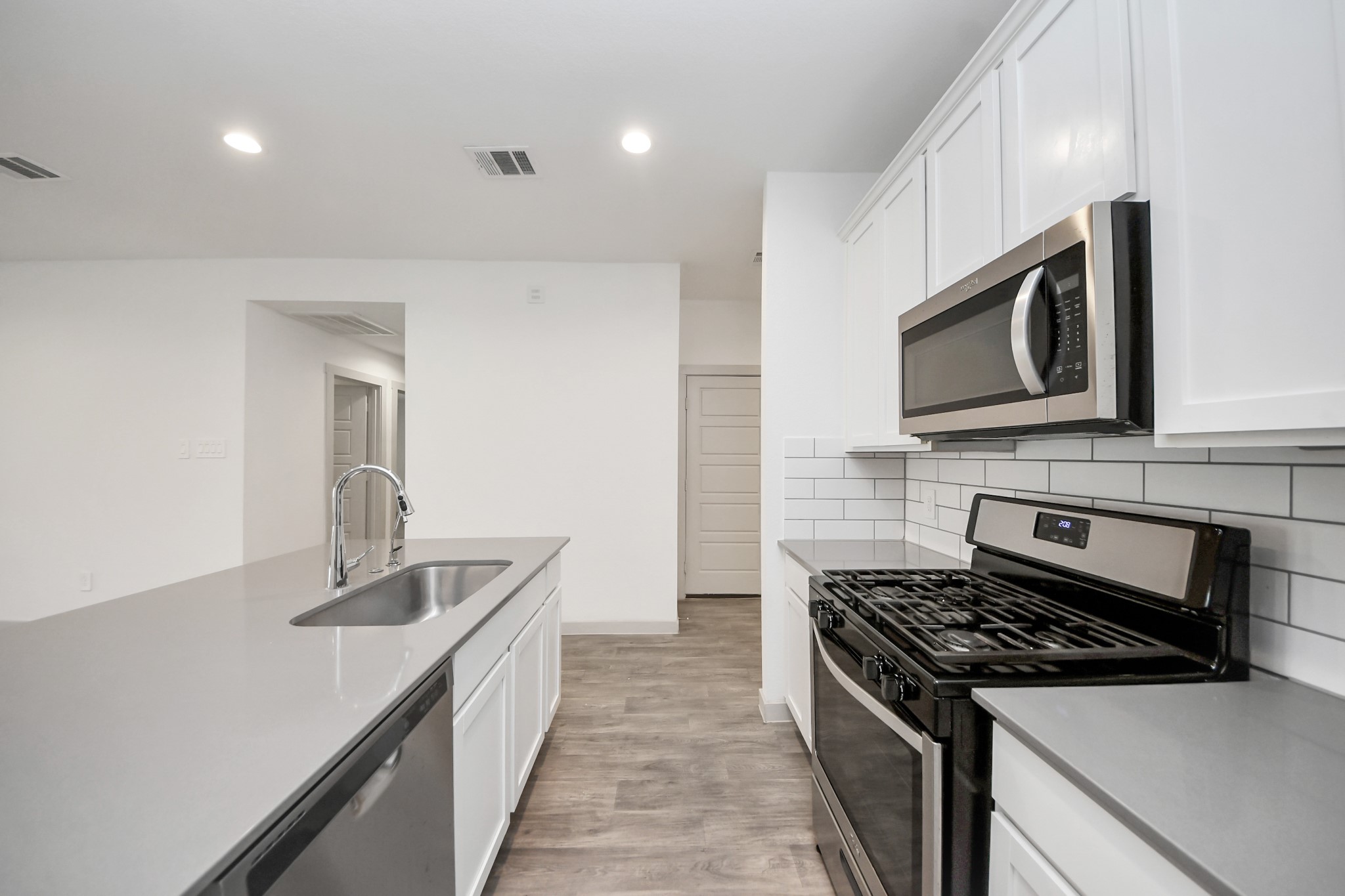 7806 Cattleman Vly Drive Rosharon, TX 77583 - Photo 11 of 40 a kitchen with stainless steel appliances granite countertop a sink stove and microwave