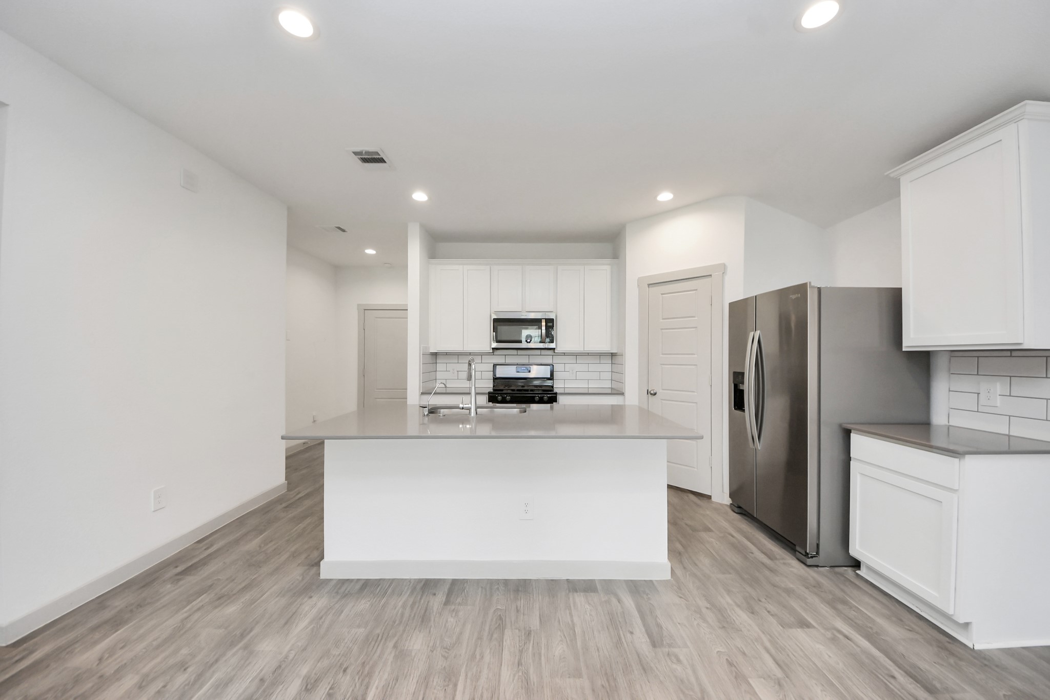 7806 Cattleman Vly Drive Rosharon, TX 77583 - Photo 14 of 40 a large kitchen with stainless steel appliances a large counter top a stove a refrigerator and a sink