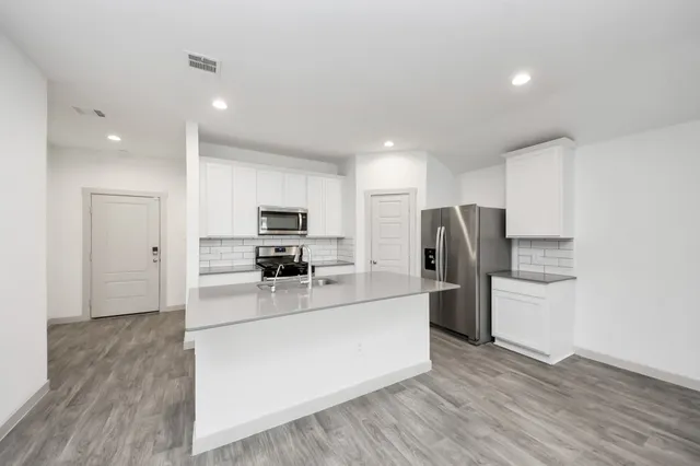 a kitchen with refrigerator and cabinets