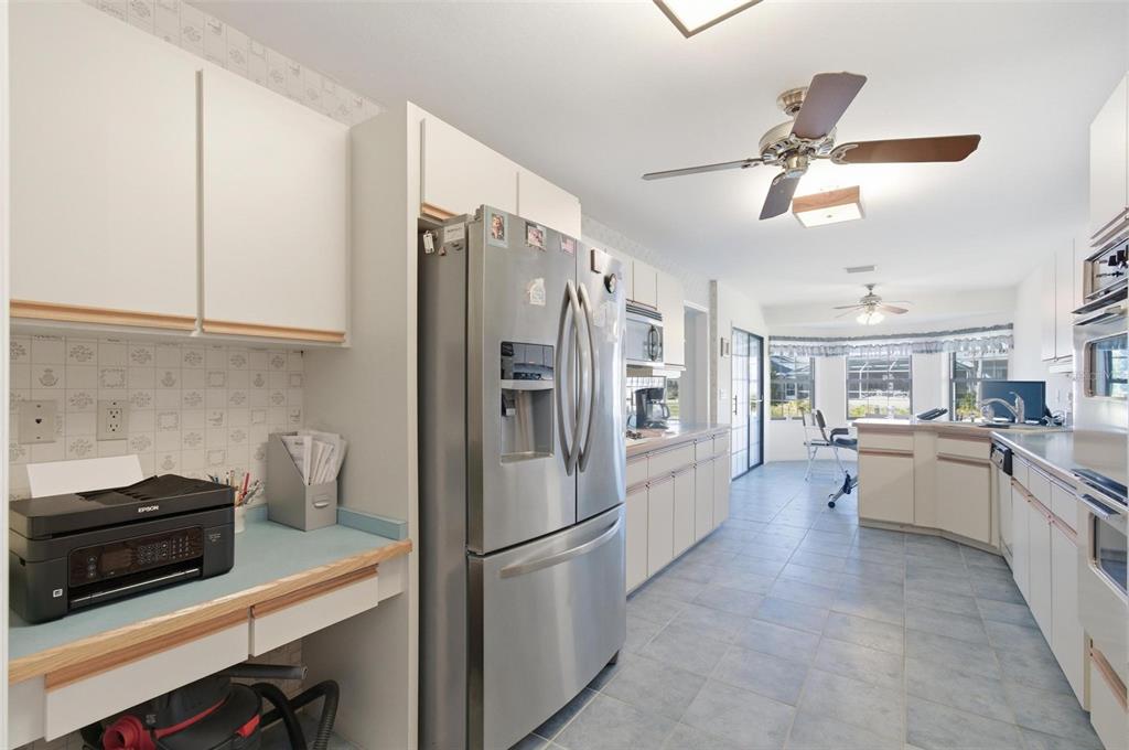 24 Chippeway Court Palm Coast, FL 32137 - Photo 16 of 69 a kitchen with stainless steel appliances a refrigerator a stove a sink dishwasher and white cabinets with wooden floor