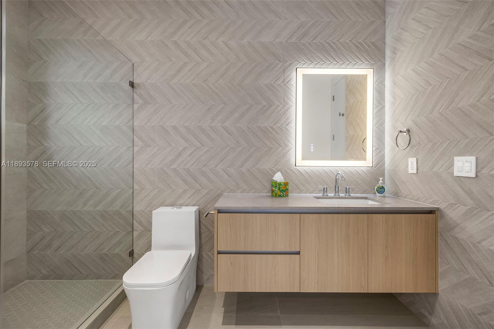 3300 Southwest 27th Terrace, Unit 3300 Miami, FL 33133 - Photo 29 of 76 a bathroom with a granite countertop toilet sink and mirror