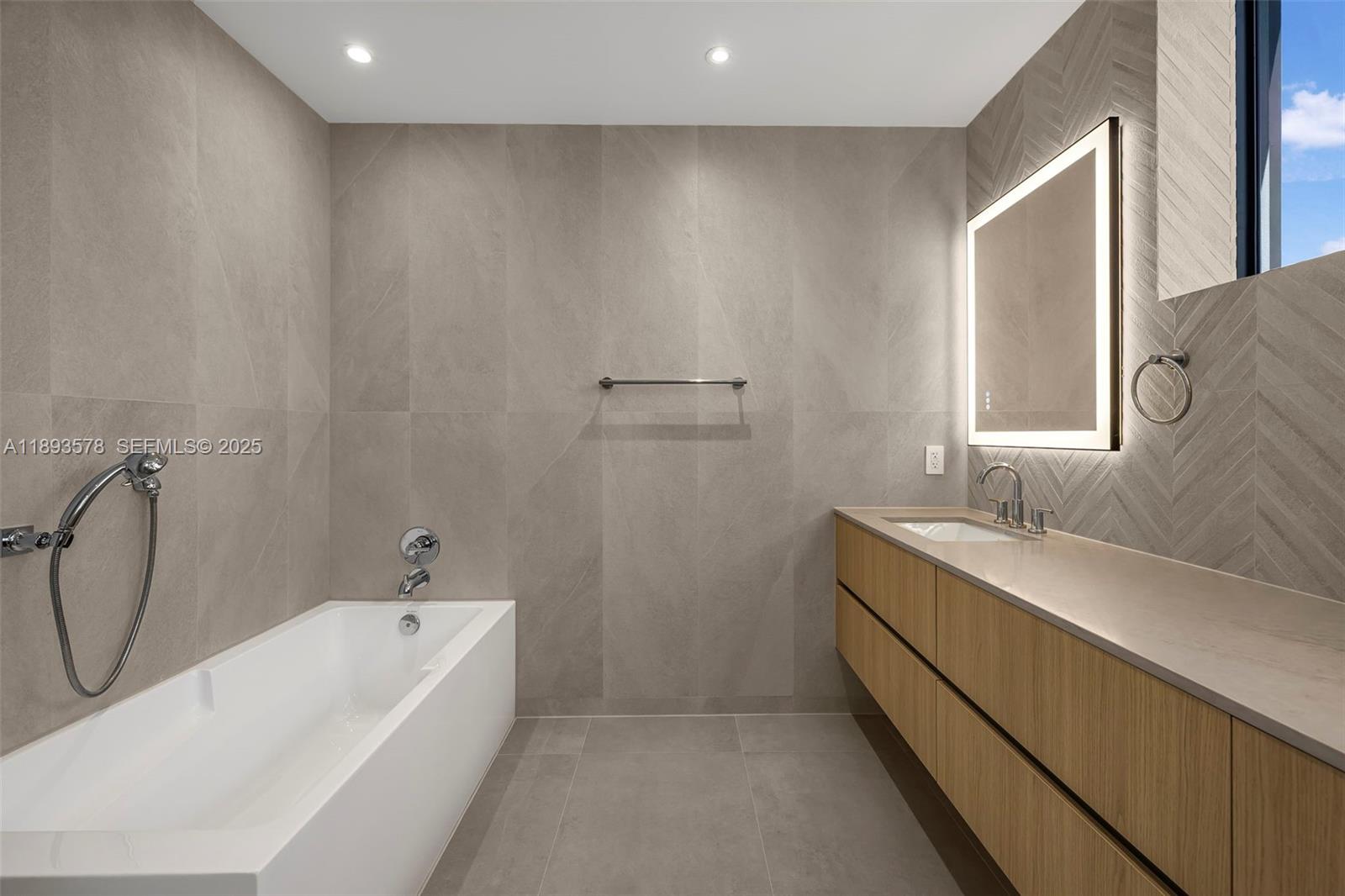 3300 Southwest 27th Terrace, Unit 3300 Miami, FL 33133 - Photo 37 of 76 a bathroom with a tub sink and mirror