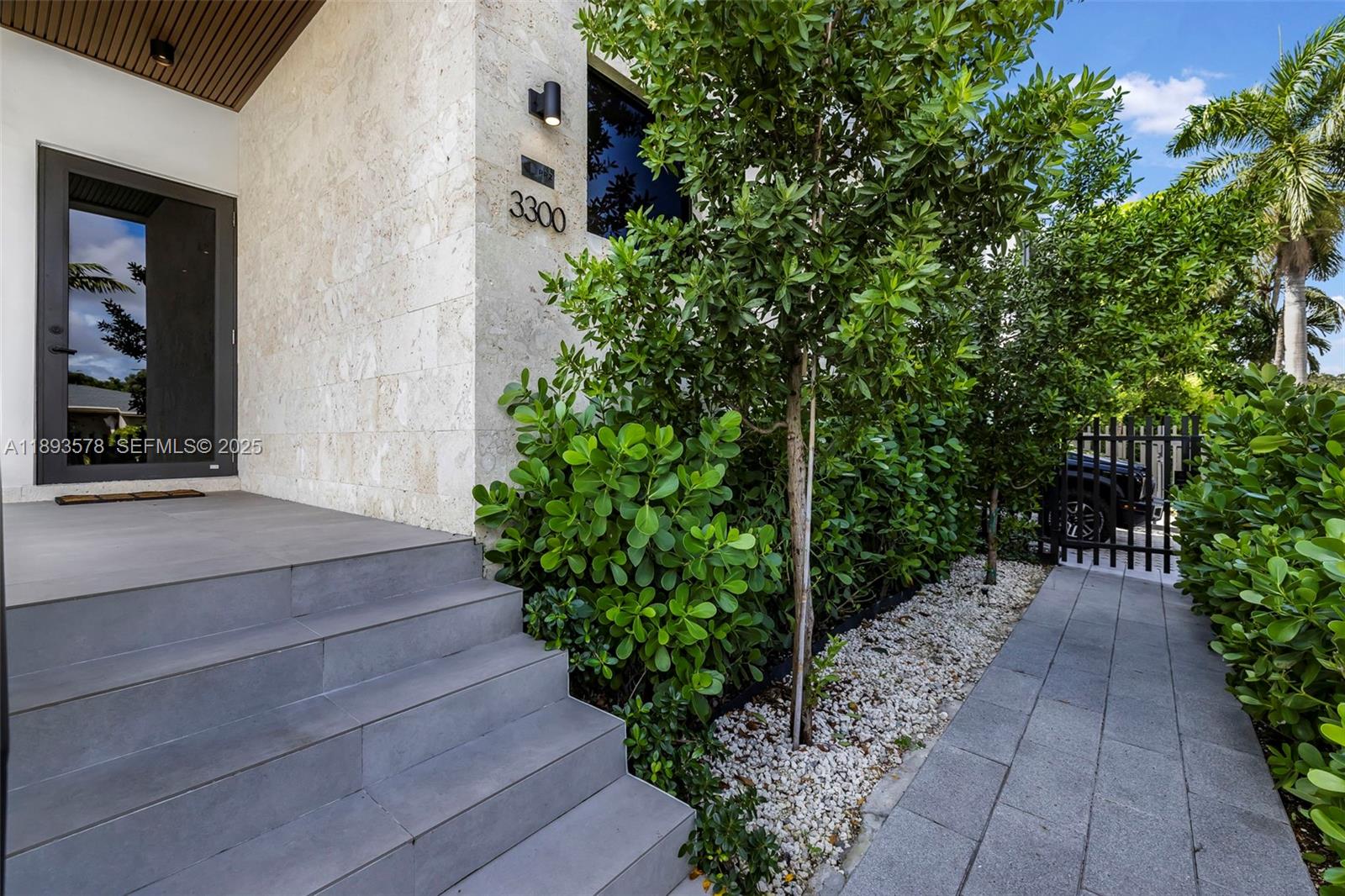 3300 Southwest 27th Terrace, Unit 3300 Miami, FL 33133 - Photo 5 of 76 a view of a pathway with potted plants and large tree