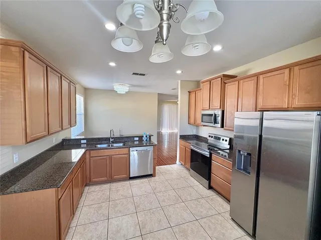 a large kitchen with granite countertop stainless steel appliances and a sink