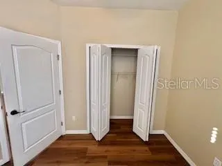 an empty room with wooden floor and closet