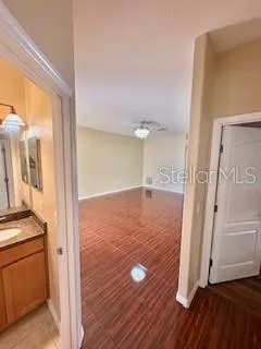 a view of a hallway with wooden floor and cabinet