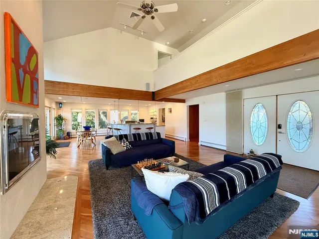 a living room with furniture kitchen view and a large window