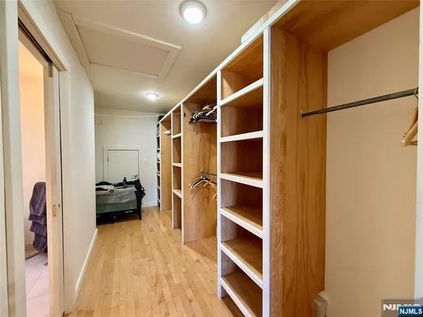 a view of walk in closet with clothes and shoes