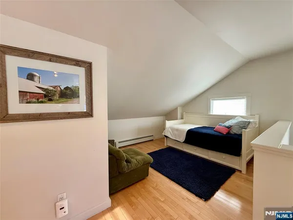 a bedroom with a bed and a painting on the wall