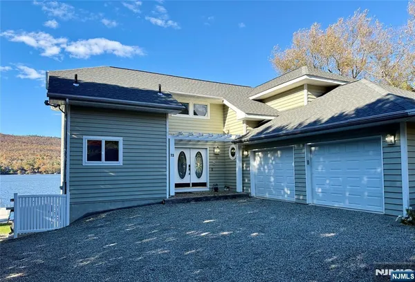 a view of a swimming pool with a lounge chairs in front of a house