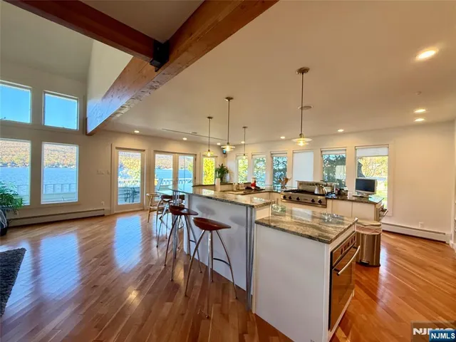 a kitchen with a table chairs stove and wooden floor