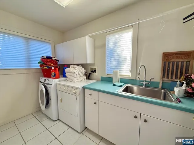 a utility room with sink dryer and washer