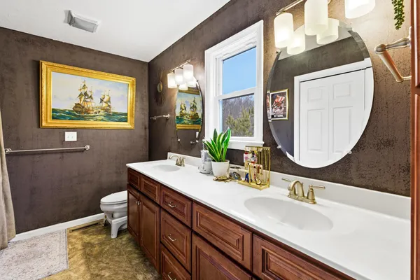 a bathroom with a sink mirror vanity and toilet