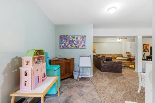 a living room with furniture and a baby crib