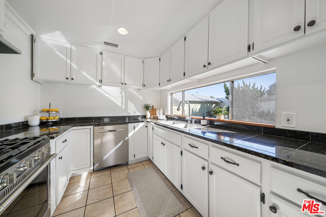4516 Walnut Avenue Long Beach, CA 90807 - Photo 11 of 35 a kitchen with granite countertop white cabinets and white appliances
