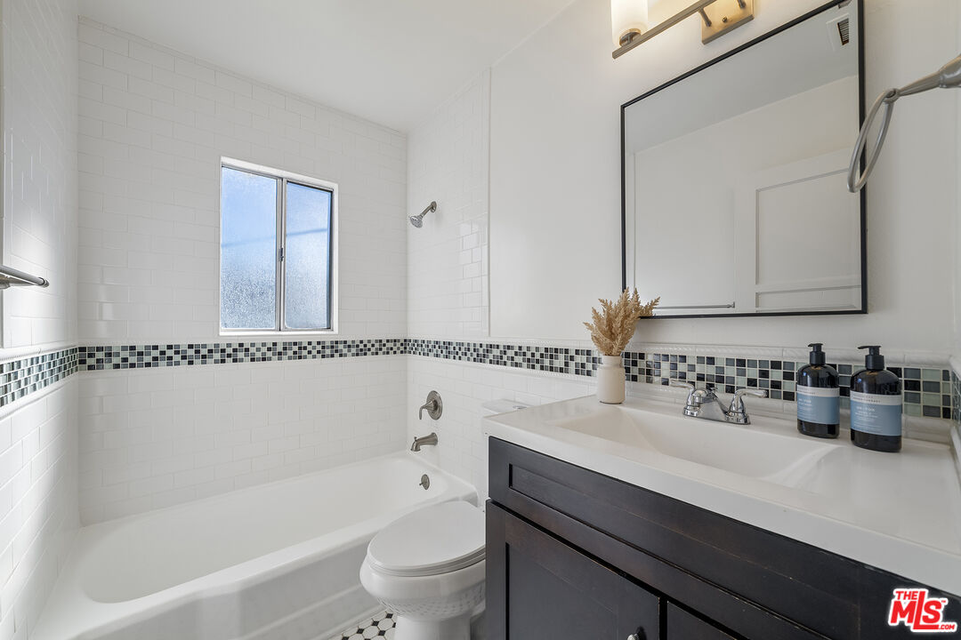 4516 Walnut Avenue Long Beach, CA 90807 - Photo 16 of 35 a bathroom with a sink a toilet a mirror and shower