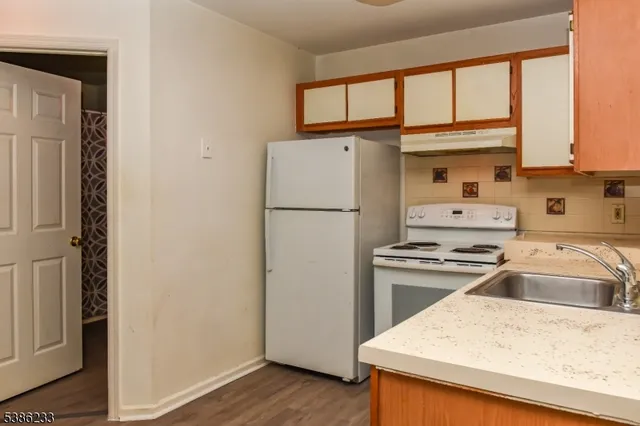 a kitchen with a refrigerator a stove top oven and a window