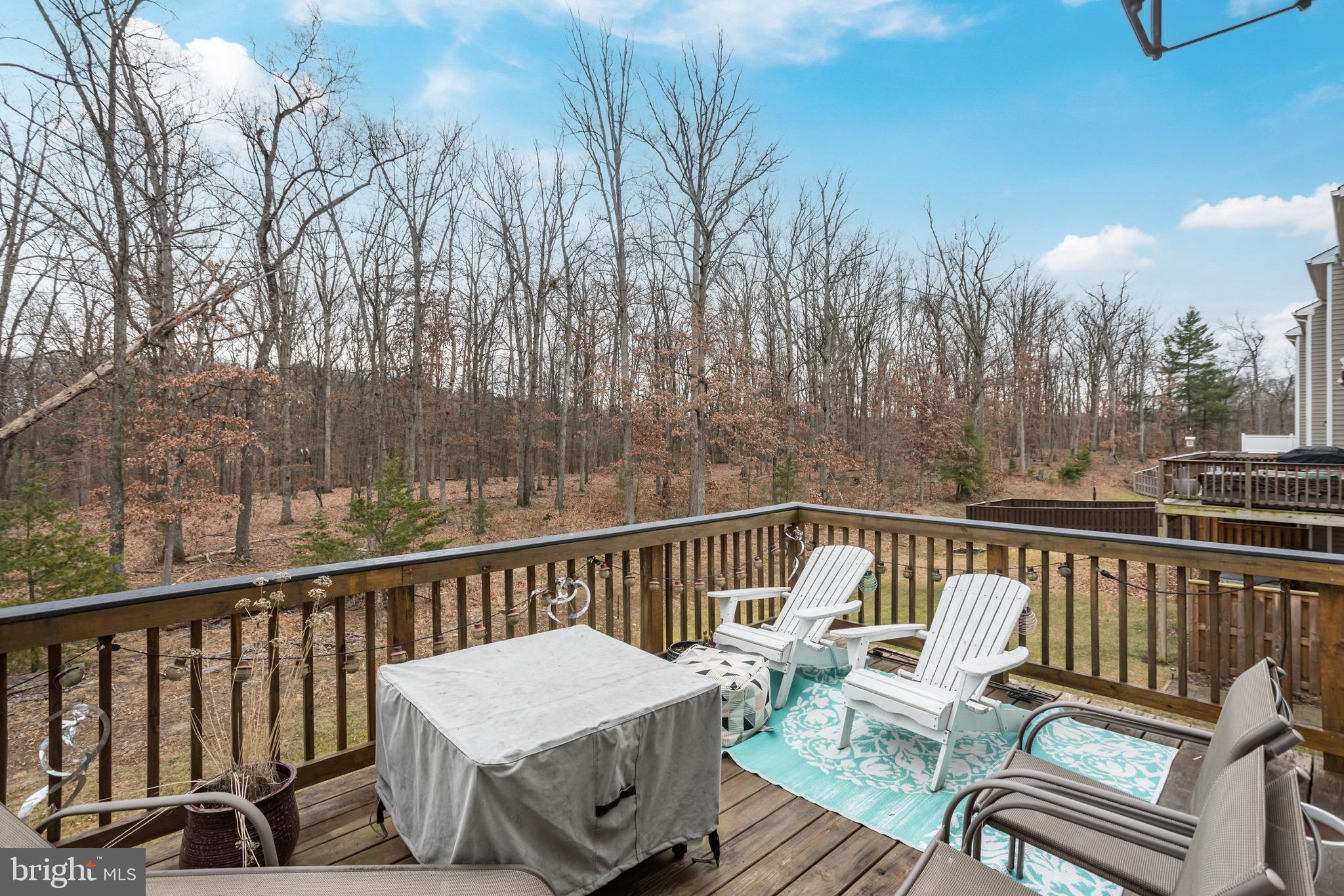 148 Solara Drive Winchester, VA 22602 - Photo 17 of 32 a view of a chair and tables on the deck