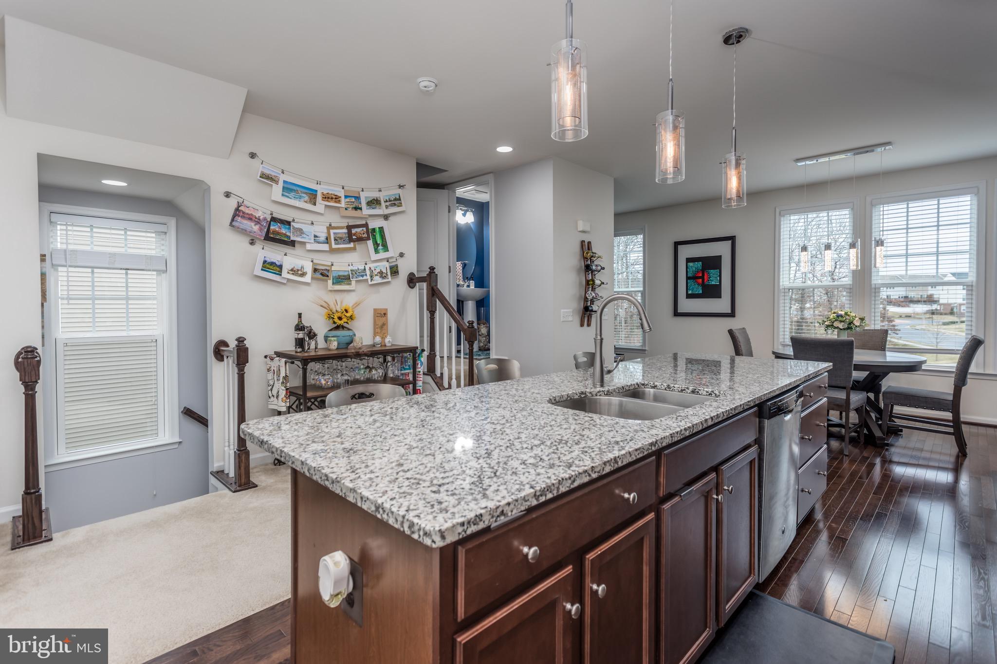 148 Solara Drive Winchester, VA 22602 - Photo 8 of 32 a kitchen with granite countertop center island a wooden floor and living room view