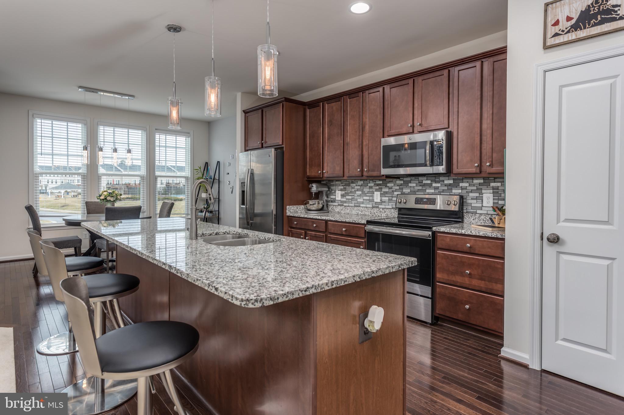 148 Solara Drive Winchester, VA 22602 - Photo 9 of 32 a kitchen with kitchen island granite countertop a sink cabinets and stainless steel appliances