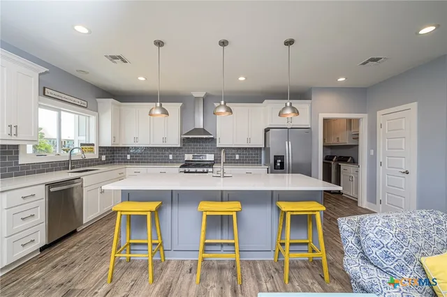 a large kitchen with a table and chairs in it